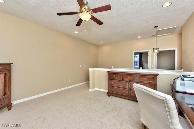 carpeted office featuring a textured ceiling and ceiling fan