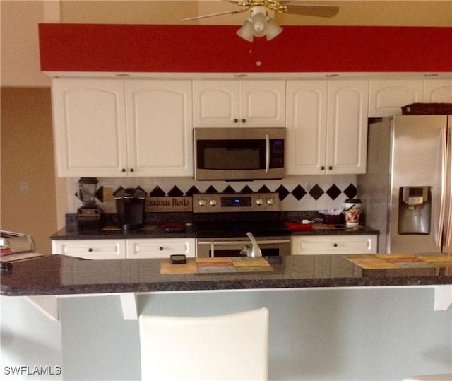 kitchen featuring ceiling fan, white cabinets, stainless steel appliances, and tasteful backsplash