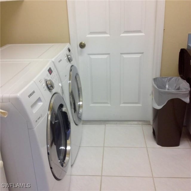 laundry area with washer and dryer and light tile patterned floors