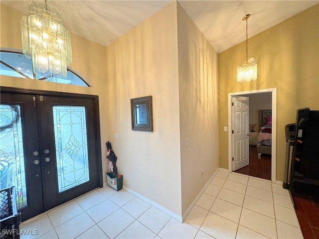 entryway with french doors, lofted ceiling, a chandelier, and light tile patterned flooring