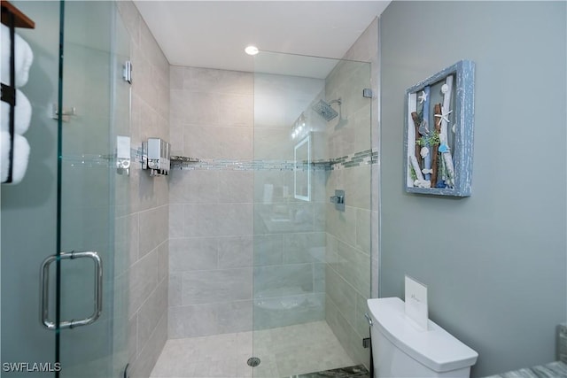 bathroom with toilet and a shower with shower door