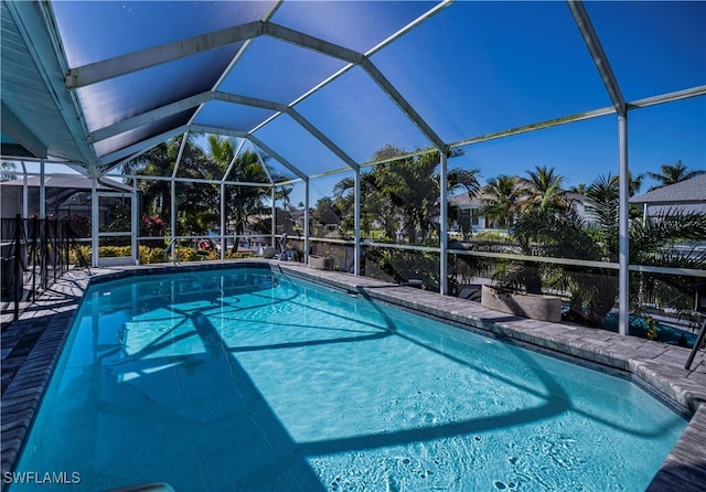 view of swimming pool featuring glass enclosure