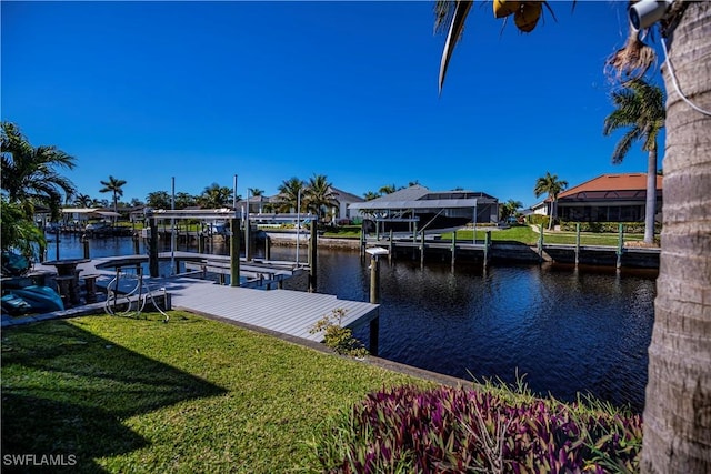 view of dock featuring a water view and a yard