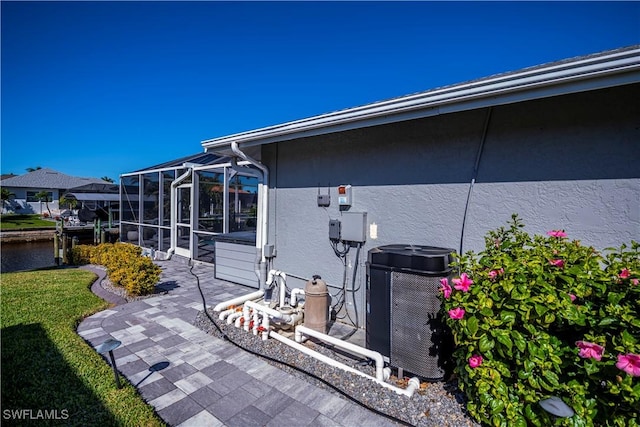 exterior space with a water view, a lanai, and cooling unit