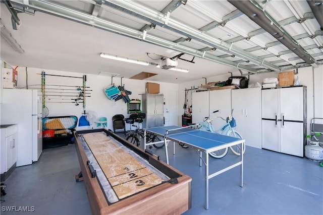 garage featuring a garage door opener and white refrigerator