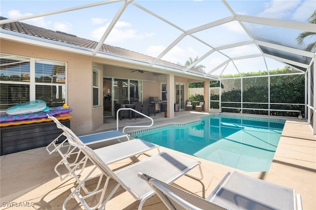 view of swimming pool with glass enclosure, a patio area, and ceiling fan