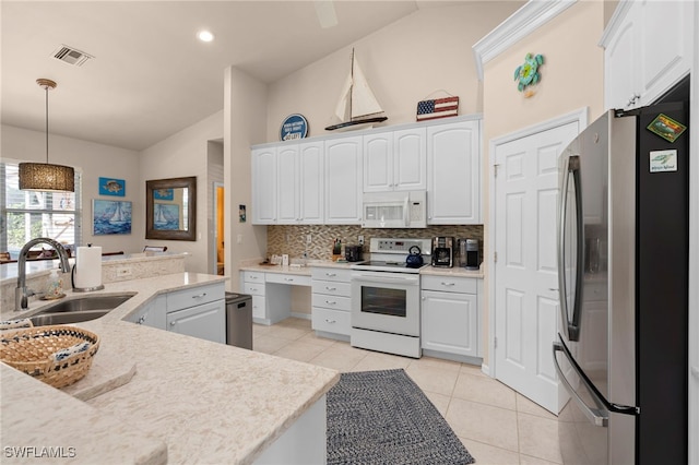 kitchen featuring vaulted ceiling, white cabinetry, decorative light fixtures, and appliances with stainless steel finishes