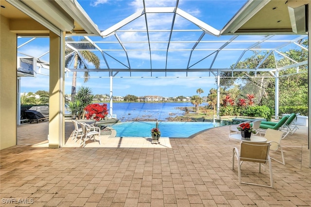 view of pool with a lanai, a patio, an in ground hot tub, and a water view