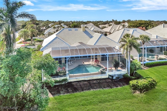 back of house with a lanai, a patio area, and a yard