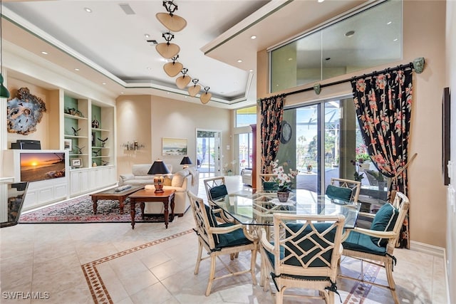 tiled dining room with built in shelves and a tray ceiling