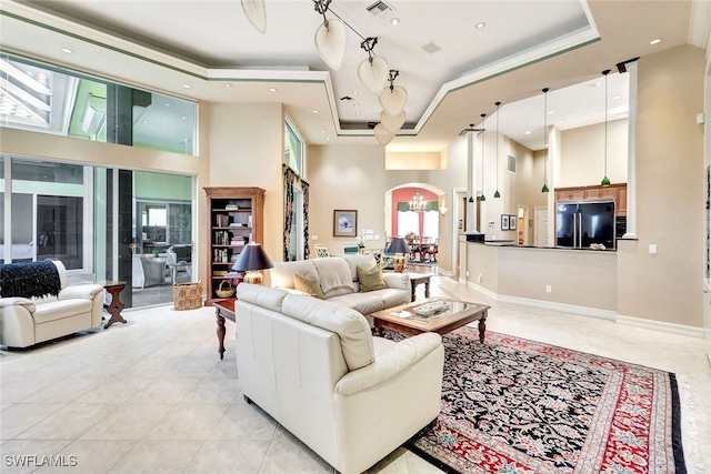 4200 Sanctuary Way, Bonita Springs, FL 34134 - living room featuring arched walkways, a tray ceiling, healthy amount of natural light, a towering ceiling, and light tile patterned flooring