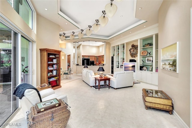 living room with a high ceiling and a tray ceiling