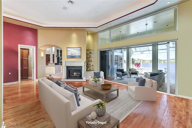 4200 Sanctuary Way, Bonita Springs, FL 34134 - living area featuring a tray ceiling, a towering ceiling, arched walkways, wood finished floors, and recessed lighting
