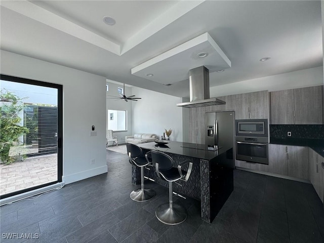 kitchen featuring island exhaust hood, ceiling fan, and stainless steel appliances