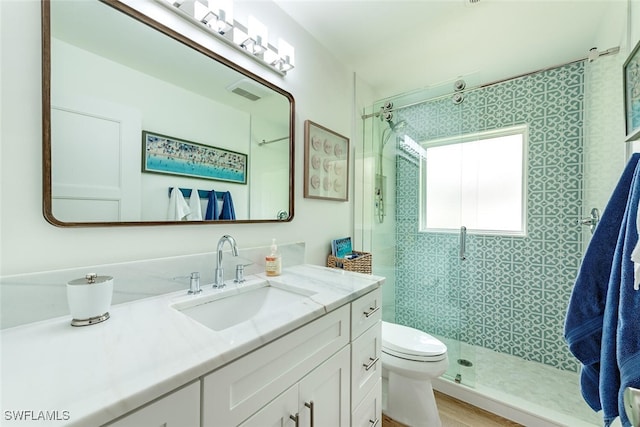 bathroom featuring vanity, toilet, and an enclosed shower