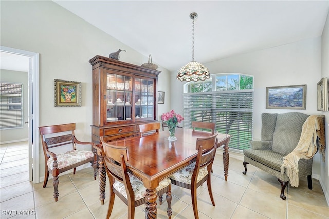 tiled dining space with lofted ceiling