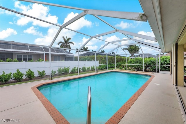 view of swimming pool featuring a patio area and a lanai