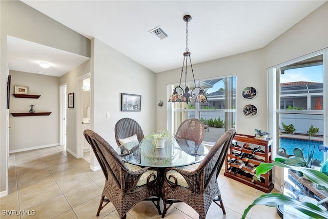 tiled dining room with a notable chandelier