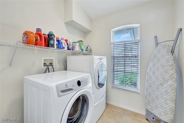 laundry area with light tile patterned flooring and washer and dryer