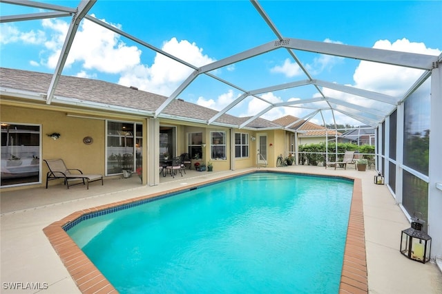 view of swimming pool with glass enclosure and a patio area