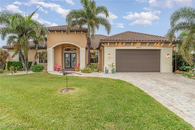 mediterranean / spanish home featuring a garage and a front yard