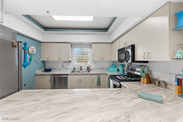 kitchen featuring appliances with stainless steel finishes, decorative backsplash, light stone countertops, and sink