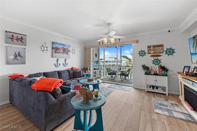 living room with hardwood / wood-style flooring, ceiling fan, and ornamental molding