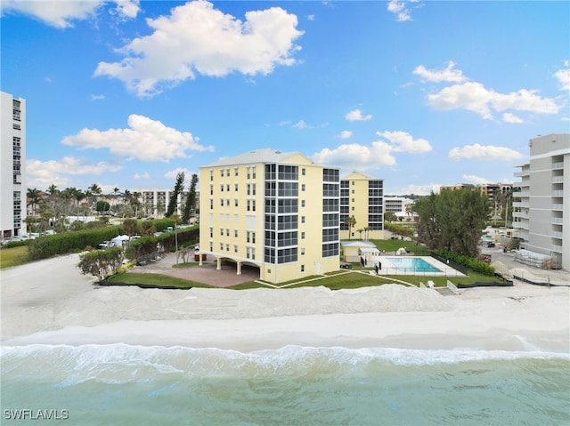 view of building exterior featuring a water view and a community pool