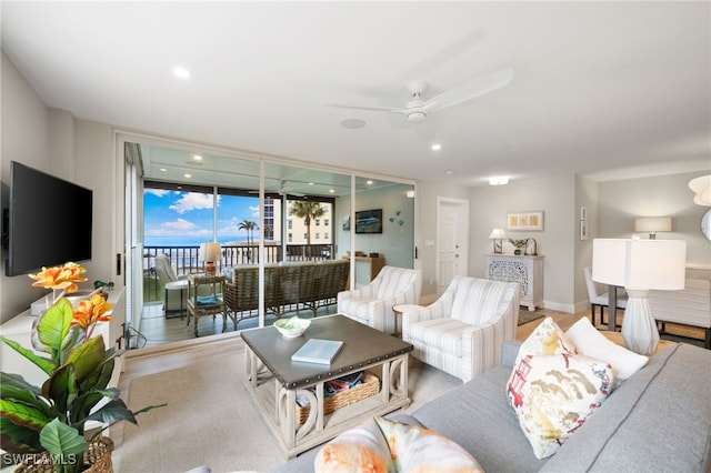 living room with a wall of windows and ceiling fan