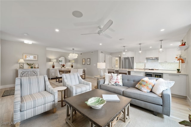 living room featuring ceiling fan and light wood-type flooring