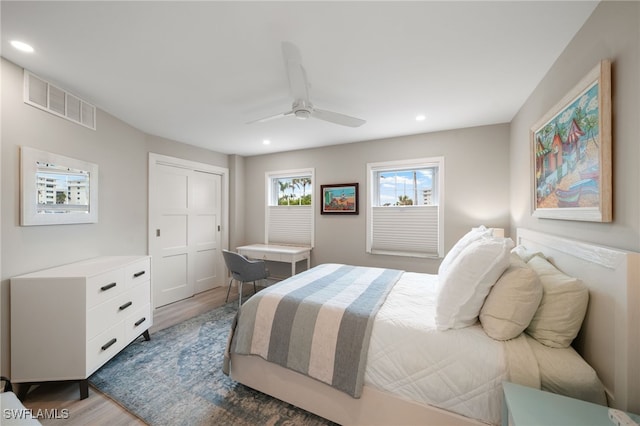 bedroom with hardwood / wood-style flooring, a closet, and ceiling fan