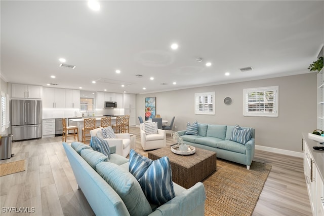 living room with crown molding and light hardwood / wood-style flooring