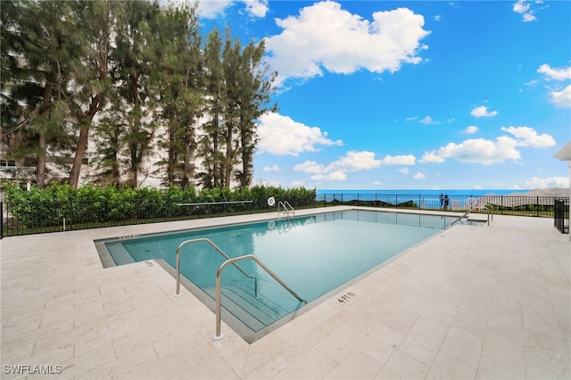 view of swimming pool featuring a water view and a patio area