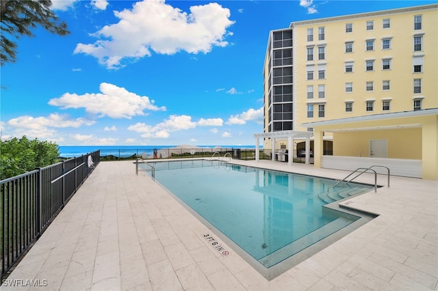 view of pool featuring a patio and a water view