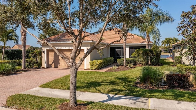 mediterranean / spanish-style house featuring a garage and a front yard