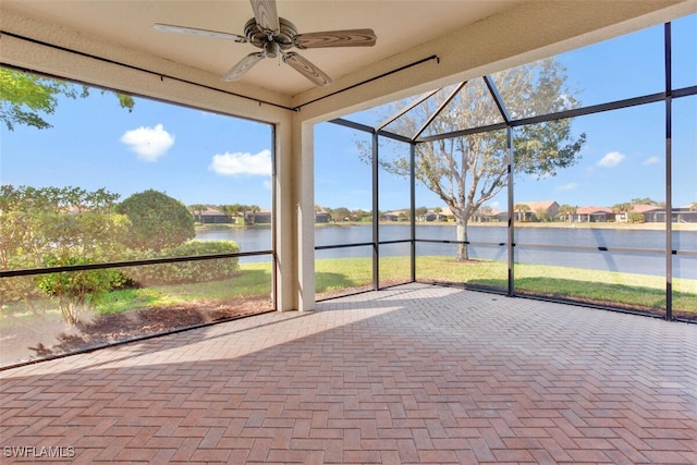 unfurnished sunroom featuring a water view and ceiling fan