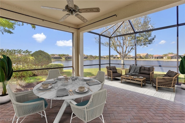 sunroom / solarium with ceiling fan and a water view