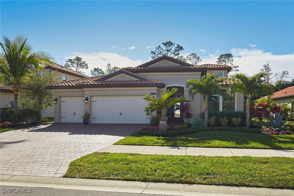 mediterranean / spanish-style house with a front lawn and a garage