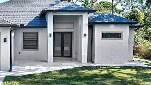 back of property with french doors, a yard, and a patio area