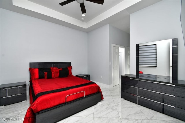 bedroom with ceiling fan and a tray ceiling