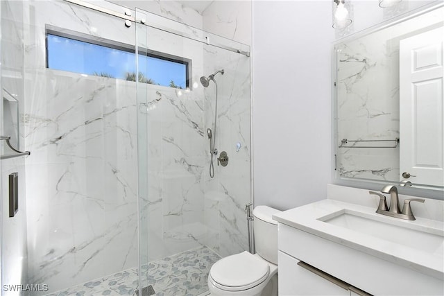 bathroom with an enclosed shower, vanity, and toilet