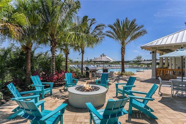 view of patio with a water view and an outdoor fire pit