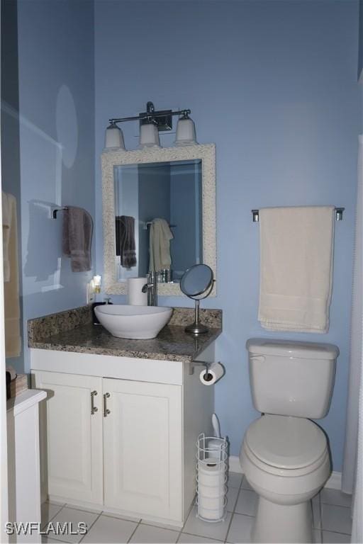 bathroom featuring tile patterned flooring, vanity, and toilet