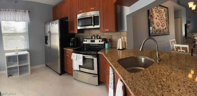 kitchen featuring backsplash, dark stone countertops, sink, and stainless steel appliances