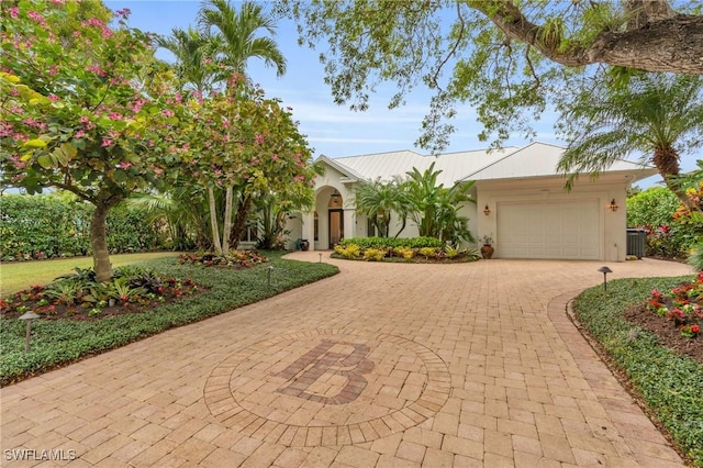 view of front of house featuring a garage and cooling unit