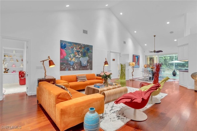 living room featuring high vaulted ceiling, light hardwood / wood-style floors, built in features, and ceiling fan