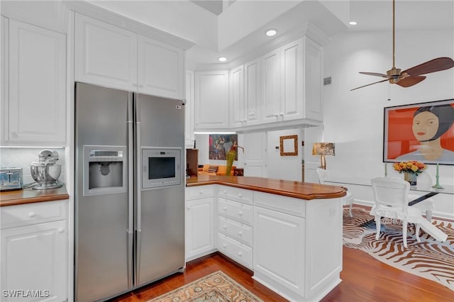 kitchen featuring stainless steel refrigerator with ice dispenser, ceiling fan, backsplash, light wood-type flooring, and white cabinets