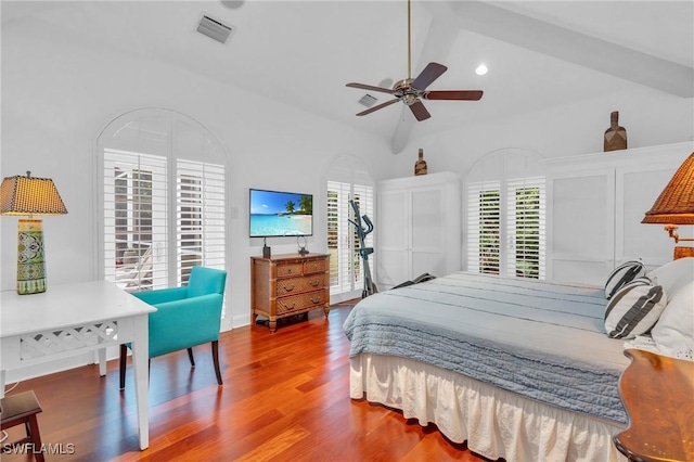 bedroom featuring ceiling fan, vaulted ceiling, multiple windows, and wood-type flooring