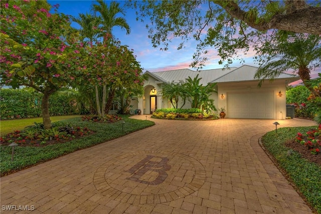 view of front of home featuring cooling unit and a garage