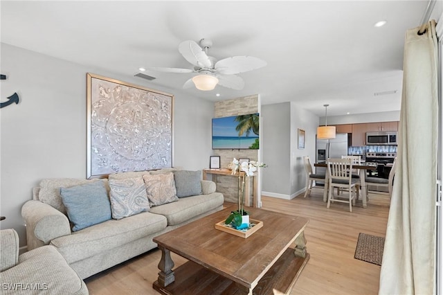 living room featuring light wood-type flooring and ceiling fan